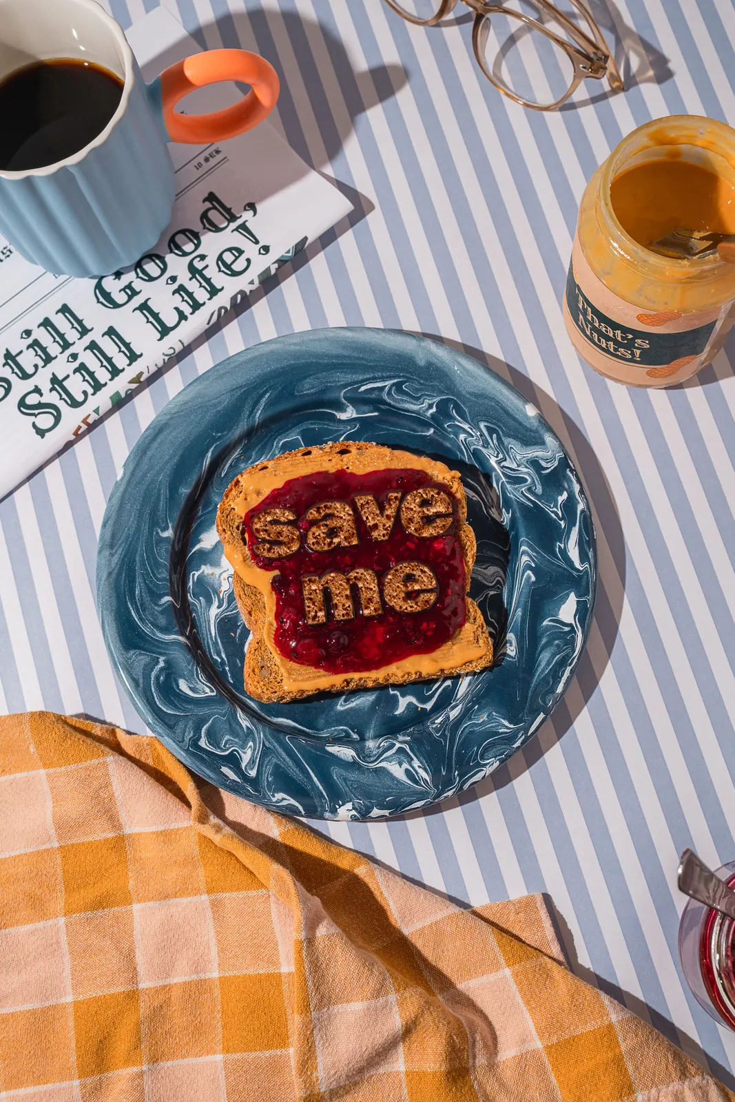 Toast spelling save me in jam on a striped tablecloth