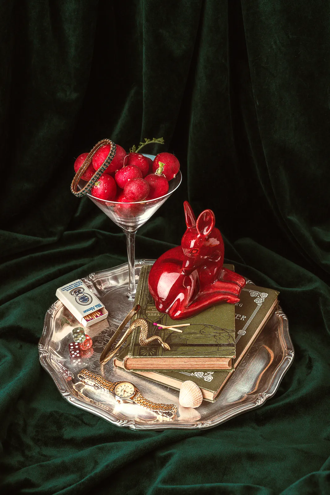 Radishes in a martini glass on a silver tray on green velvet