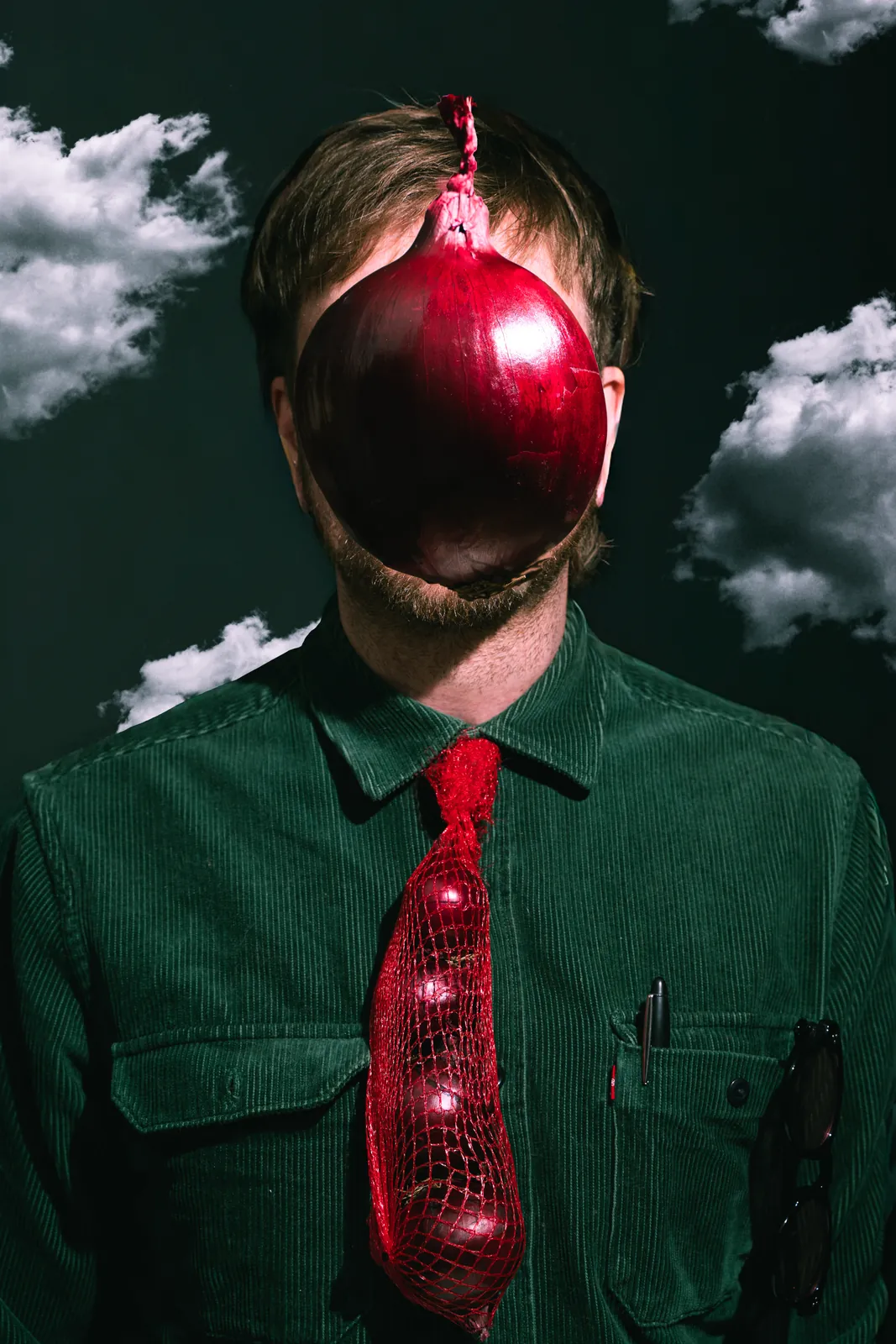 A man in a green shirt with a red onion over his face