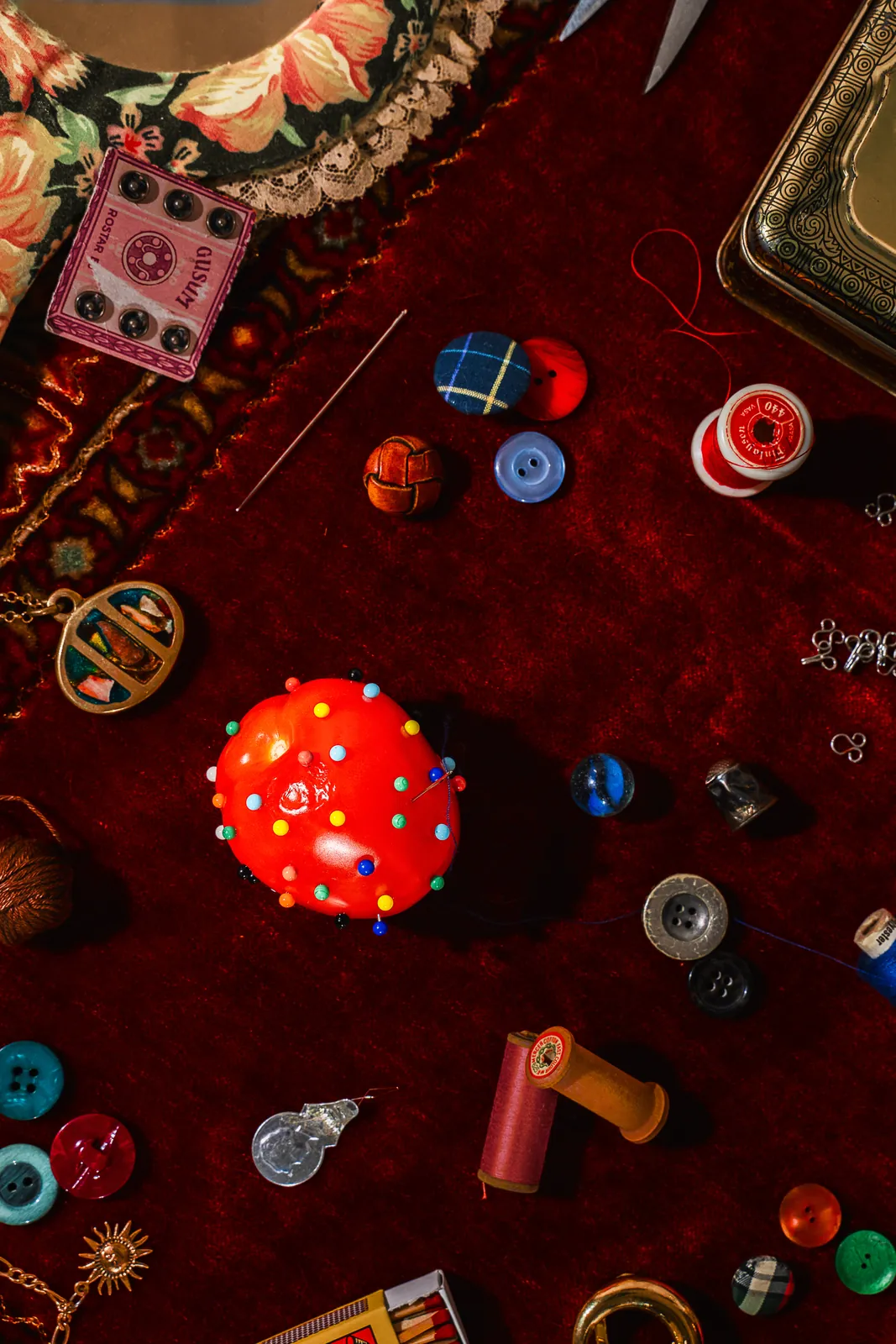 A red mushroom among buttons and trinkets on red velvet