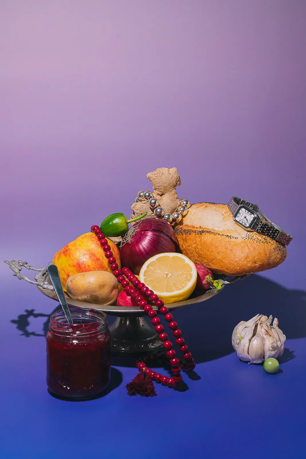 A fruit bowl with bread, jam, and beads on lilac