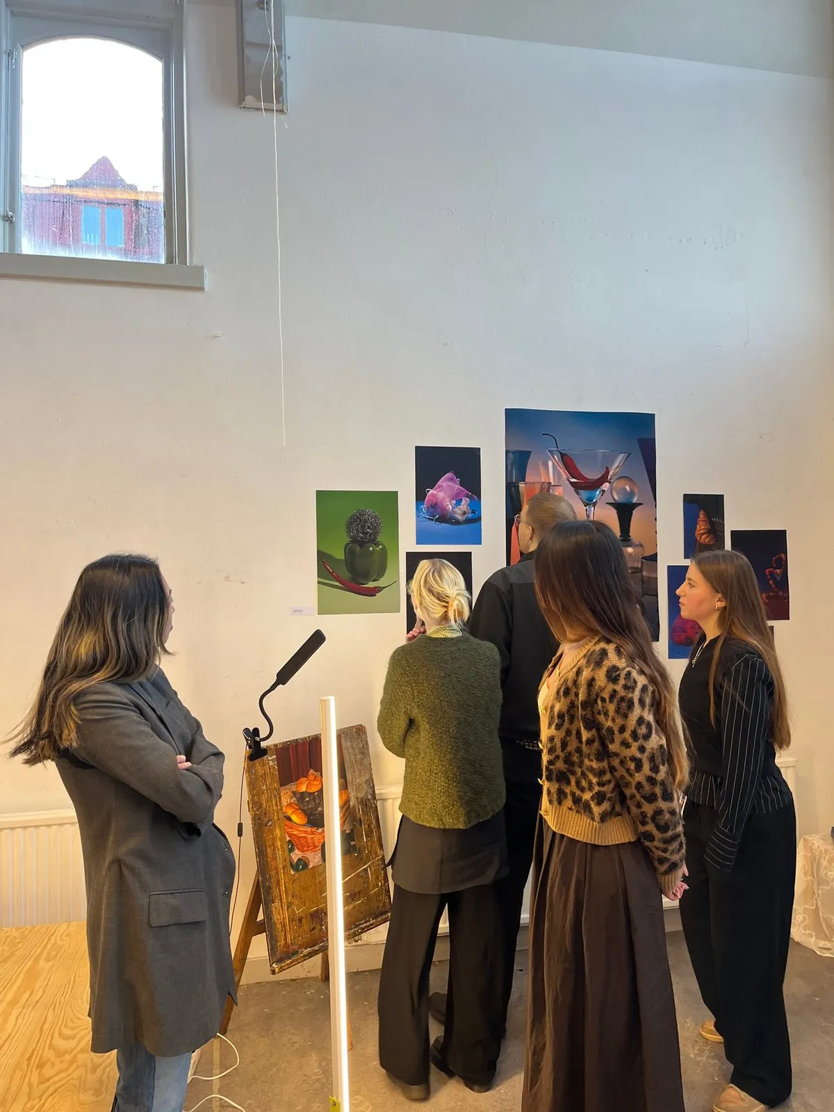 Visitors looking at the Still Good, Still Life photographs on a white wall