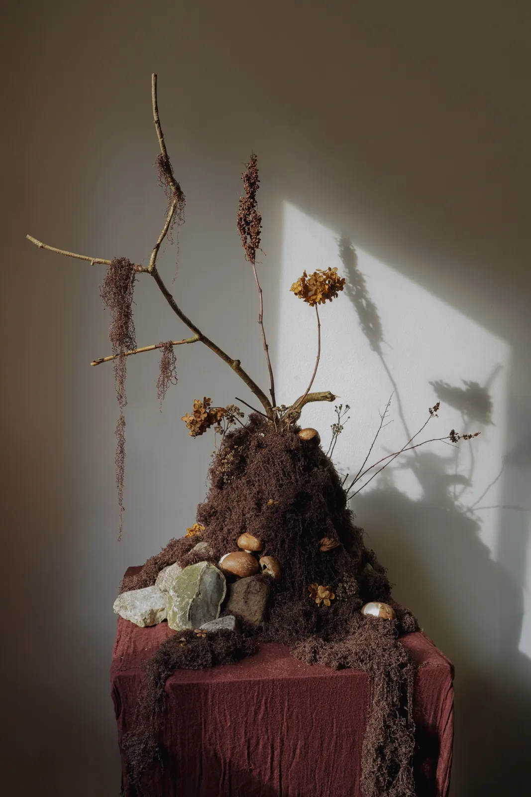 A moss and dried-flower centrepiece with stones and mushrooms