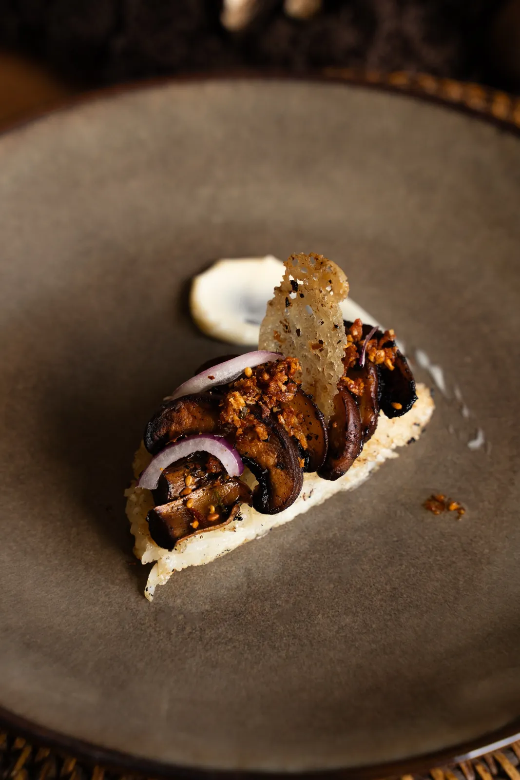 Mushroom adobo on crispy rice with a tuile