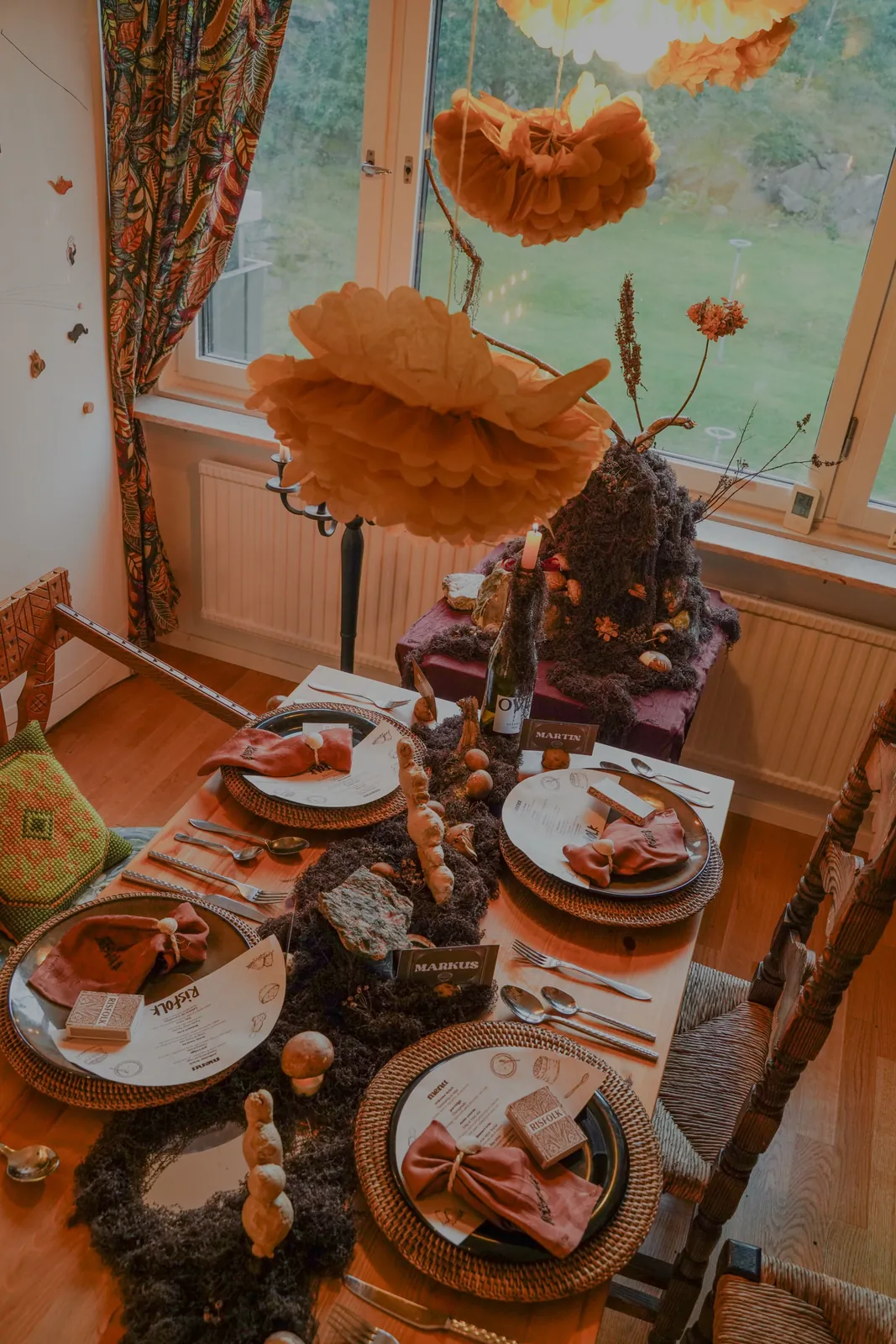 The Risfolk table set with moss, mushrooms, ginger roots, rattan chargers and paper menus