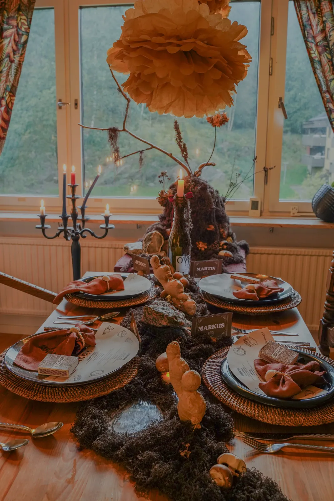The Risfolk table by the window with candles and paper pompoms
