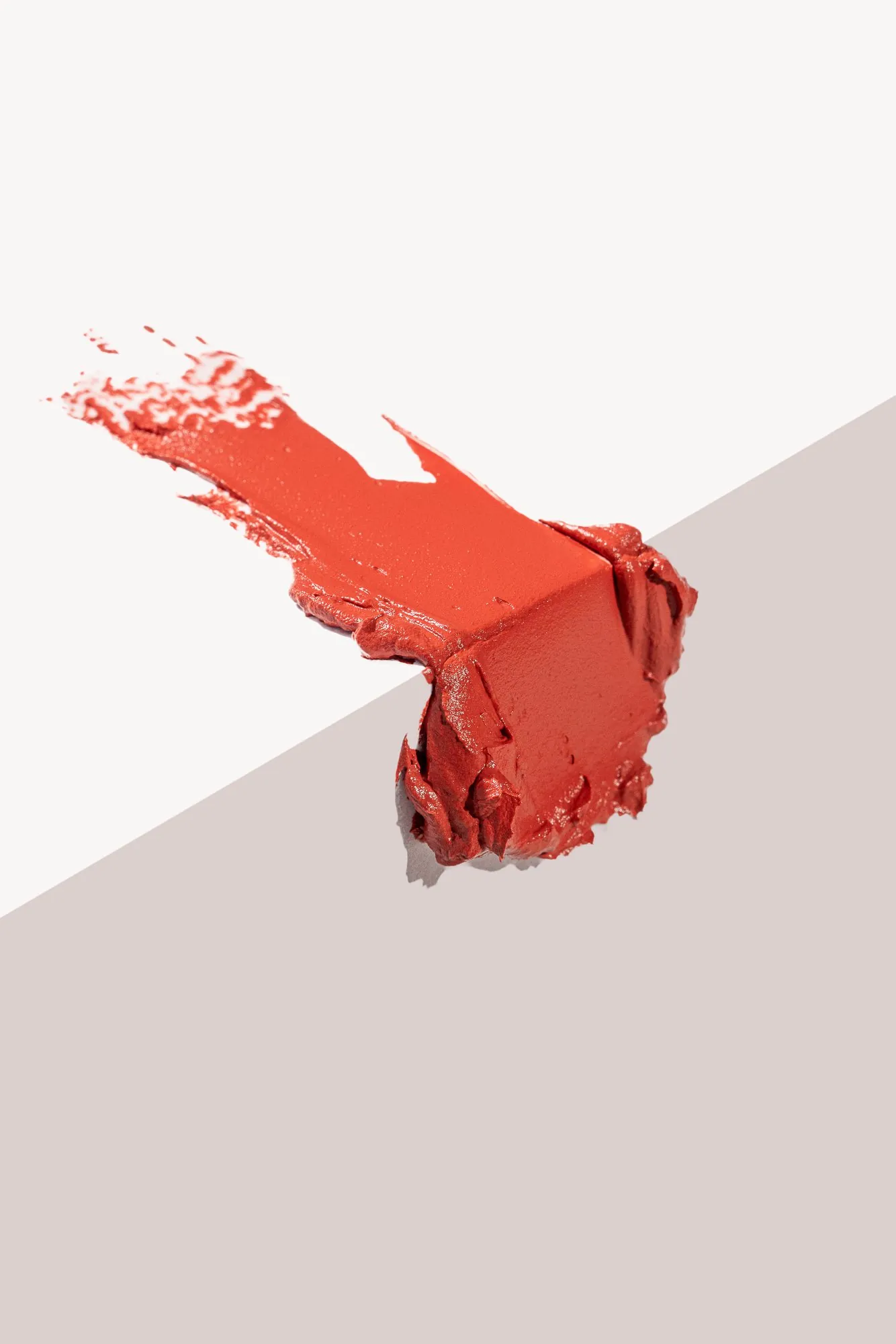 A coral lipstick smeared across a pale corner