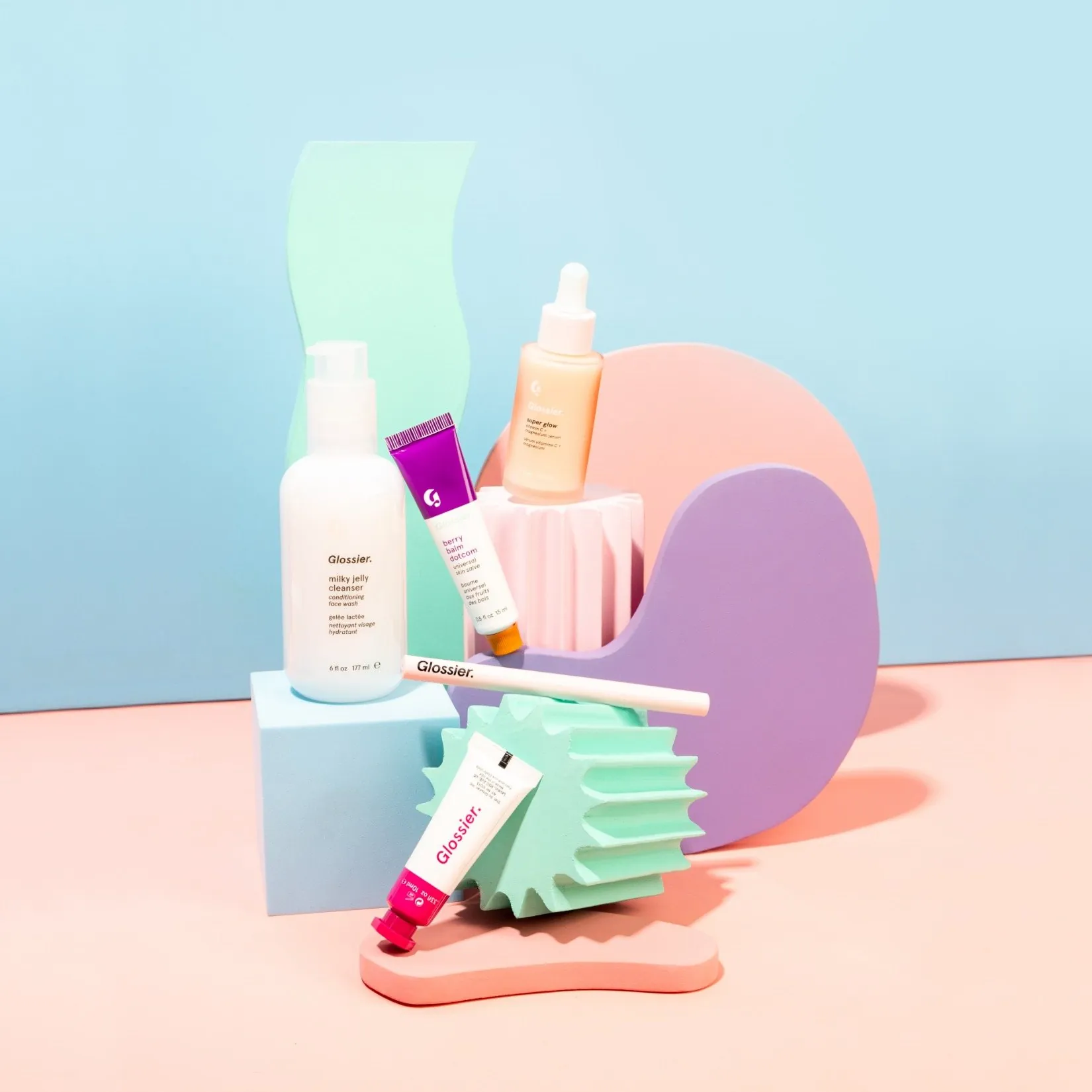 Glossier products among pastel foam shapes