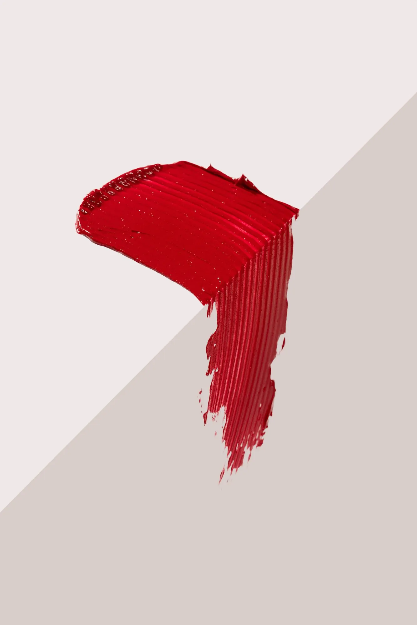 A bright red lipstick swipe on a white and grey corner