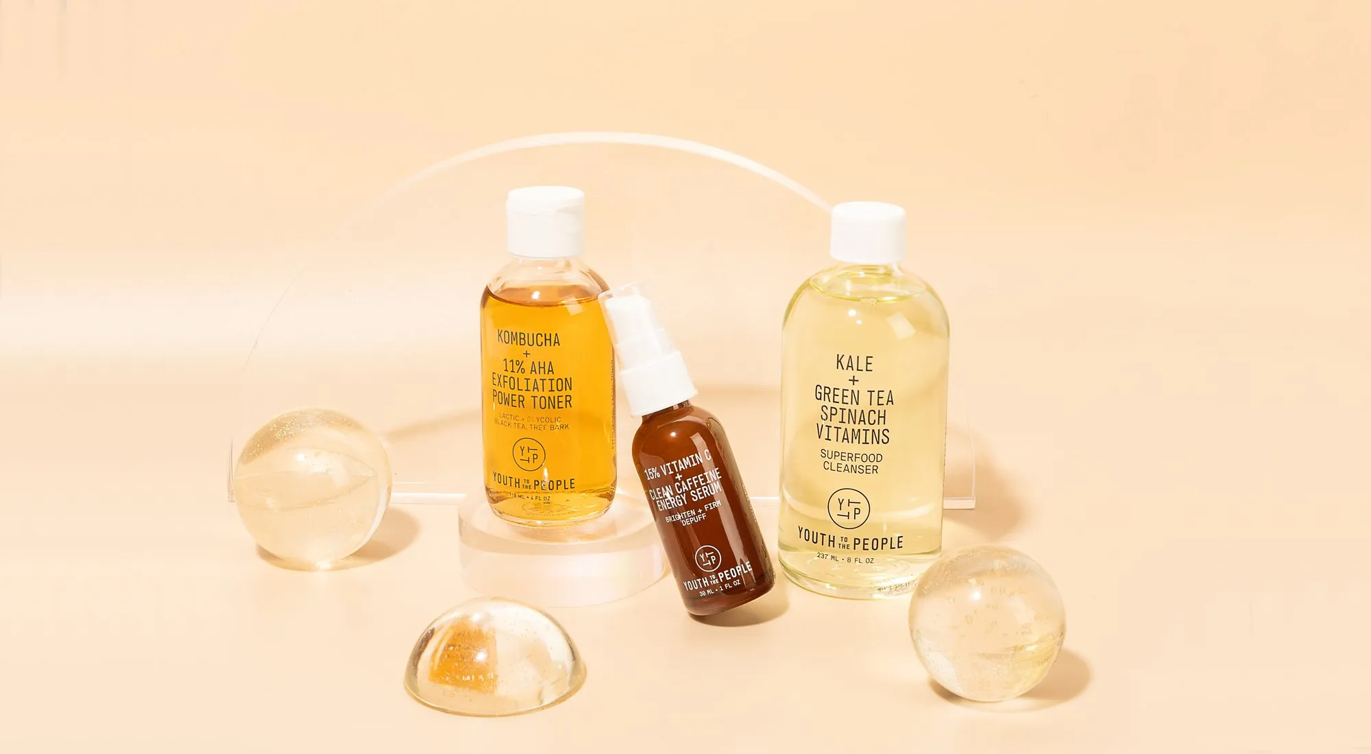 Youth to the People bottles with glass spheres on peach